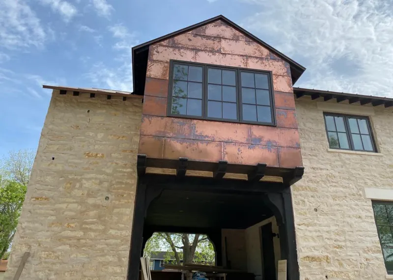 Copper metal panel facade on a stone building for Skylight Installation in New Prague